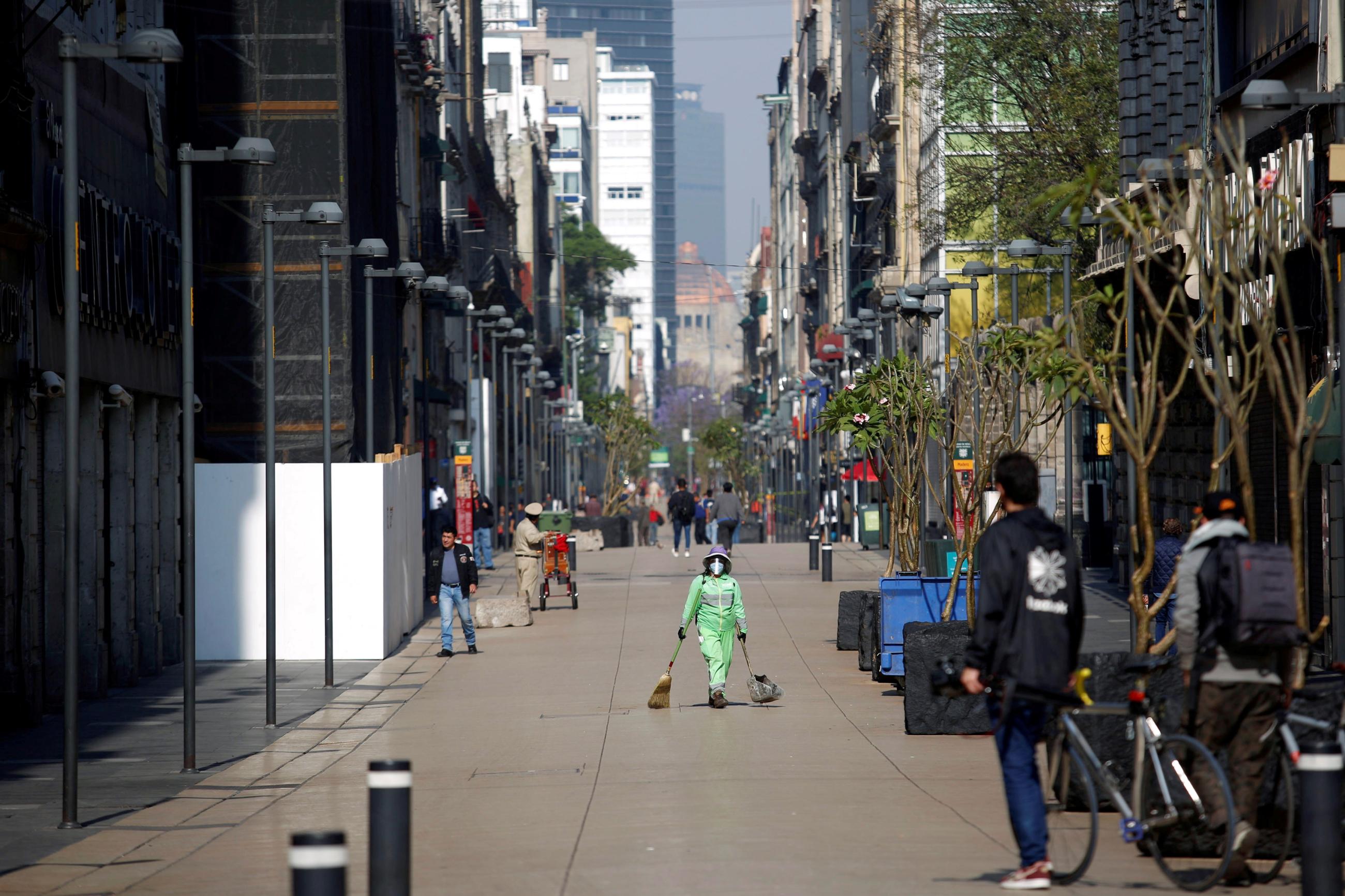 A municipal employee works on an empty street during the COVID-19 outbreak, in Mexico City, Mexico, on March 29, 2020.