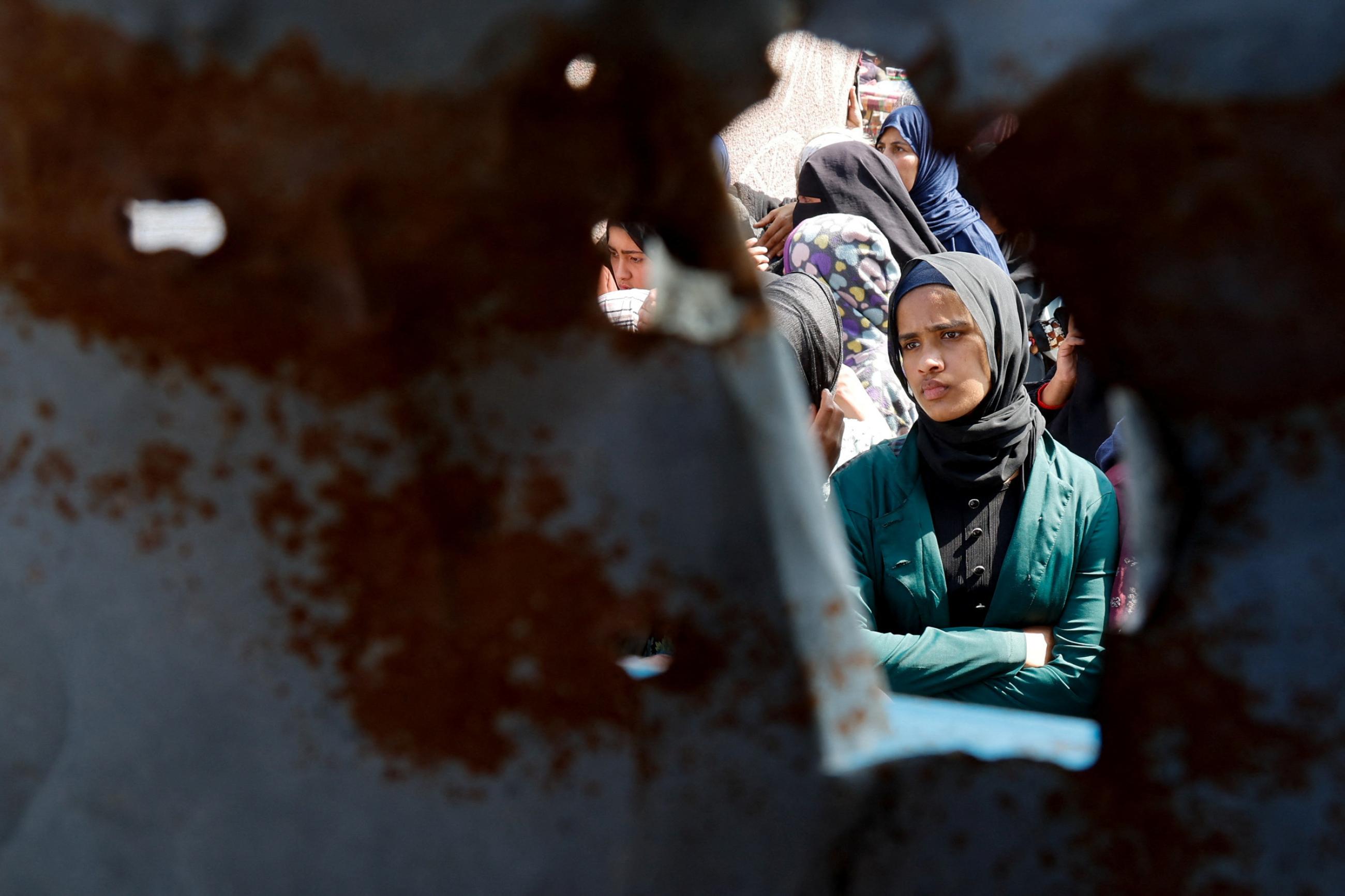 A Palestinian woman looks on as she and others gather to receive bread from a bakery, in Khan Younis, Gaza Strip, on March 9, 2025.
