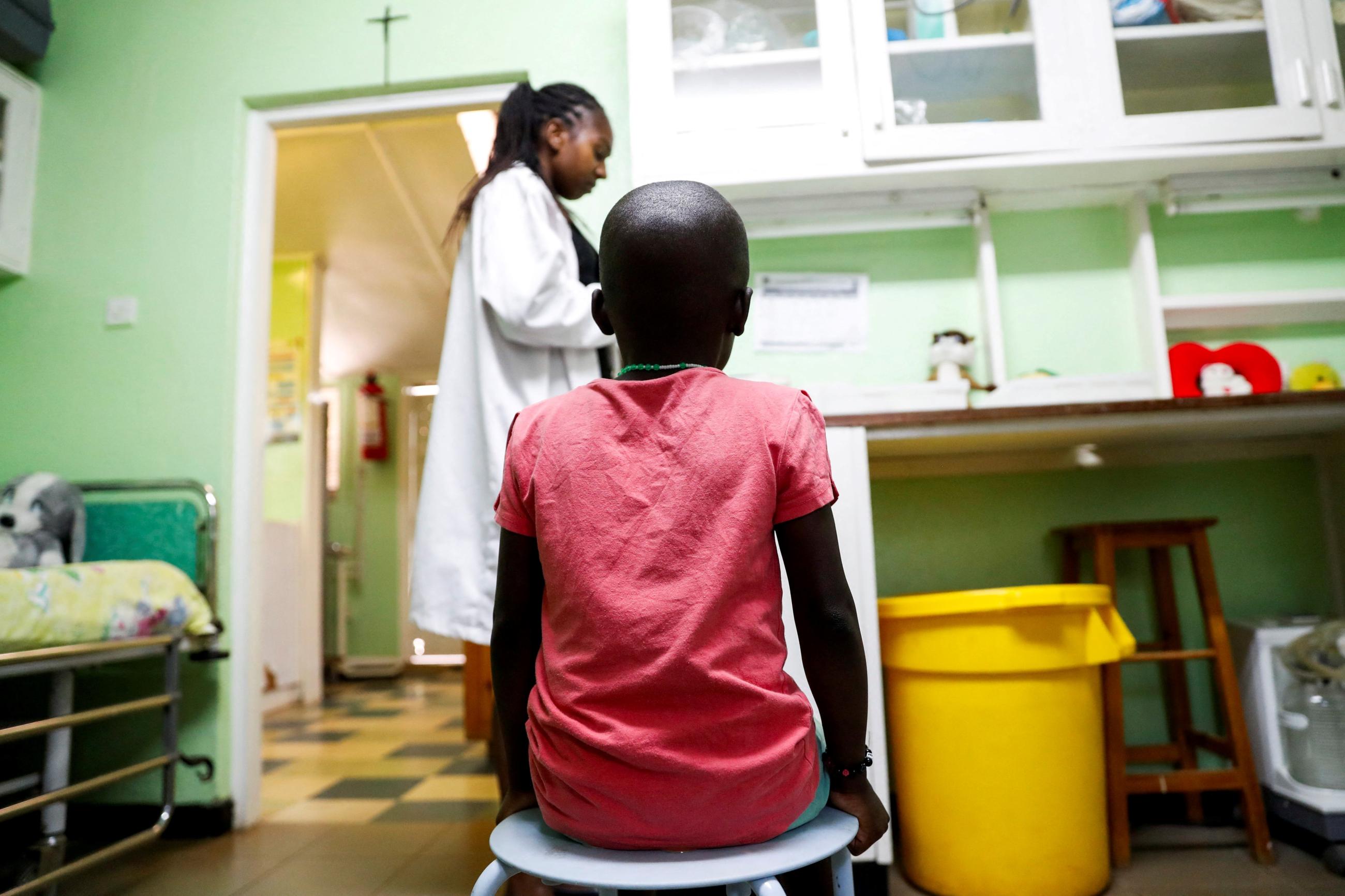 A child sits as a nurse prepares to dispense antiretroviral ARV drugs used to prevent HIV from replicating, at the Nyumbani Children's Home, Nairobi, Kenya, on February 12, 2025. 