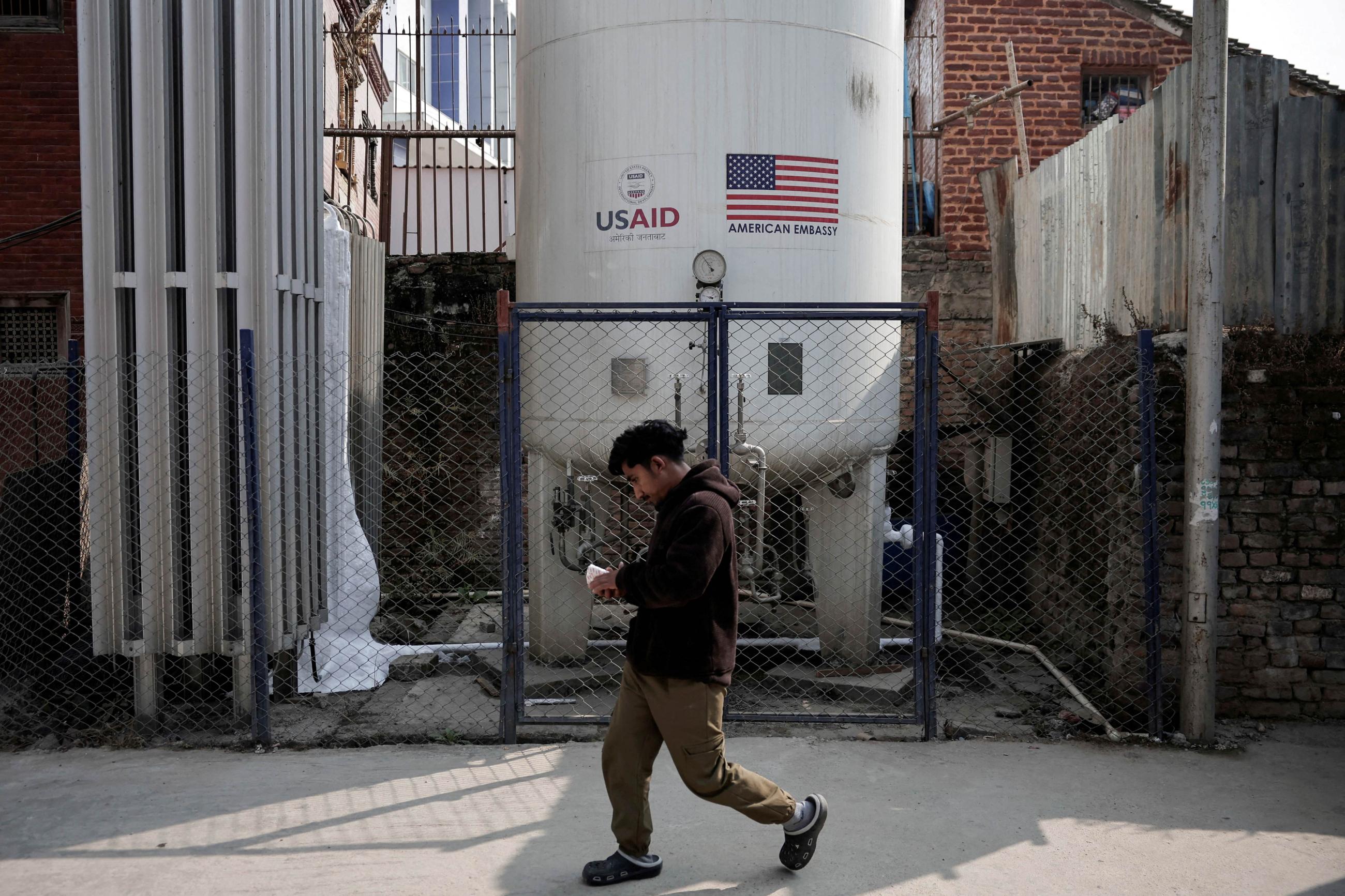 A man walks past the liquid oxygen storage tank installed at Bir Hospital by the United States Agency for International Development, in Kathmandu, Nepal, on February 9, 2025. 