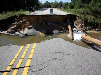 Residents inspect a washed-out section of collapsed road after Hurricane Matthew hit the state, in North Carolina.