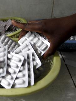 Antiretroviral drugs ready for distribution at the Mater Hospital in Kenya's capital Nairobi on September 10, 2015. Picture shows a hand reaching in and picking up a pack of the pills. REUTERS/Thomas Mukoya