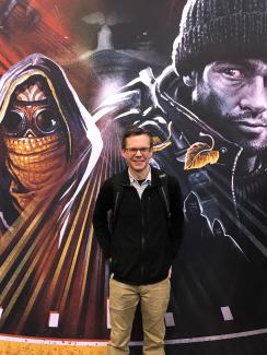 Pandemic designer Matt Leacock standing in front of a poster with some of the game’s cover art on Oct 29, 2017. Photo courtesy of Matt Leacock
