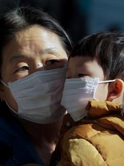 The photo shows the two face to face with each other, but their faces are covered almost completely below their eyes by the dust masks. 