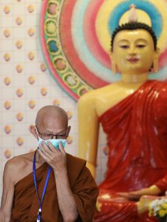 This is a striking image with the monk in the foreground and some very colourful Buddhist temple features in the background. 