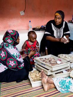 The photo shows the healer facing the camera and sitting between two other women and a child. 