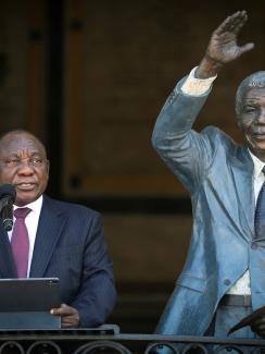 The images shows the president standing next to a life-sized statue of Nelson Mandela. 