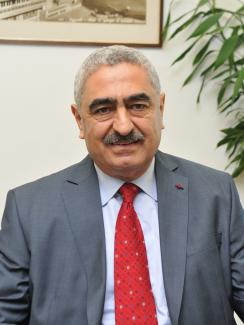 The photo shows Ammar sitting behind a desk in a portrait-type photograph.