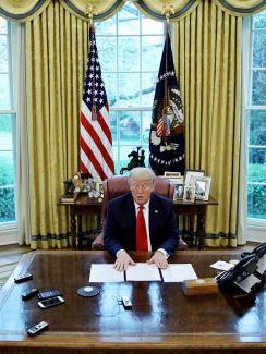The photo shows the president at his desk in the Oval Office. 
