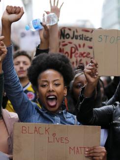 The photo shows a huge crowd with people facing the camera with homemade signs, fists raised, and shouting slogans. AFP/Daniel Leal-Olivas via Getty Images