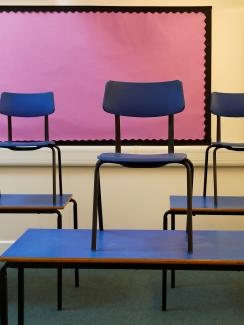 The photo shows a number of tables with chairs stacked upon them. 