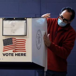 A man sanitizes a privacy booth to fight the spread of COVID-19 at a polling station in New York City, United States, on October 25, 2020. REUTERS/Andrew Kelly