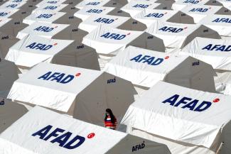 A woman walks amid a tent city set up by Turkey's Disaster and Emergency Management Presidency (AFAD) after an earthquake in the Aegean port city of Izmir, Turkey, November 1, 2020. 
