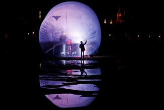 A child flies a kite inside a giant inflatable plastic bubble during a performance of the artistic group Cirk La Putyka called "Isolation" in a park, as the spread of the coronavirus disease (COVID-19) continues in Prague, Czech Republic