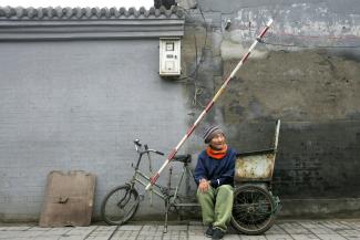 A resident rests on a bike in a "hutong", an alleyway, in Beijing, China.