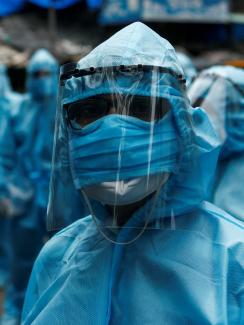 Health-care workers wait to take off their personal protective equipment after the end of a check-up camp for the COVID-19) at a slum in Mumbai, India on June 14, 2020.