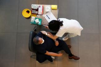 A medical worker vaccinates a man against the coronavirus disease (COVID-19) as Israel kicks off a coronavirus vaccination drive, at Tel Aviv Sourasky Medical Center (Ichilov Hospital) in Tel Aviv, Israel December 20, 2020