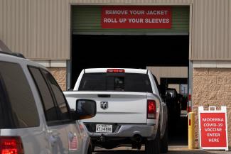 A police officer controls traffic at a drive-through COVID-19 vaccination site in Robstown, Texas on February 9, 2021.