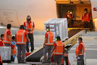 Employees unload the AstraZeneca (SKBio Corea) vaccines under the COVAX scheme against the coronavirus disease (COVID-19) from a cargo plane at the Mons. Oscar Arnulfo Romero International Airport, in San Luis Talpa, El Salvador March 11, 2021.