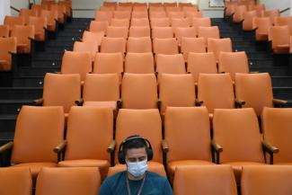 A health-care worker sits inside a monitoring room after receiving a second dose of the Pfizer/BioNTech vaccine at the Posta Central hospital in Santiago, Chile on January 14, 2021. 