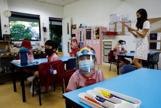 Children wearing protective face masks and shields attend preschool classes at St James' Church Kindergarten as schools reopen amid the coronavirus disease outbreak in Singapore on June 2, 2020.