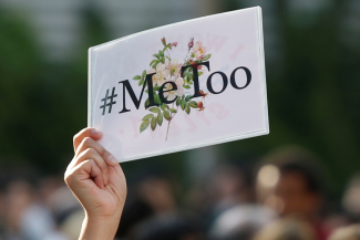 A protester's hand can be seen holding a #MeToo sign during a rally against harassment at Shinjuku shopping and amusement district in Tokyo, Japan on April 28, 2018. REUTERS/Issei Kato