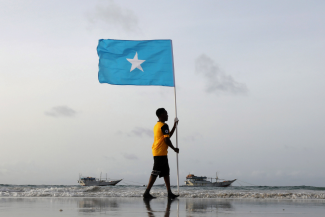 A young man holds Somalia’s national flag, at Lido beach in Mogadishu, Somalia on June 18, 2021.