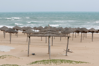 A deserted Marsa beach with umbrellas made of natural materials is pictured during an extended lockdown aimed at stemming the spread of COVID-19 in April 2020 in Tunis, Tunisia.