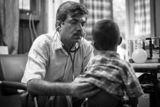 Dr. Yogesh Jain examines a young boy who has sickle cell disease for pneumonia, located in a remote village clinic that does not have any x-ray facilities, in May 2017 at  Jan Swasthya Sahyog community health program