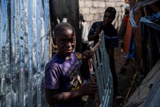 Boys working at a metal recycler carry metal scavenged from houses destroyed in a 7.2 magnitude quake in Les Cayes, Haiti, on August 21, 2021.