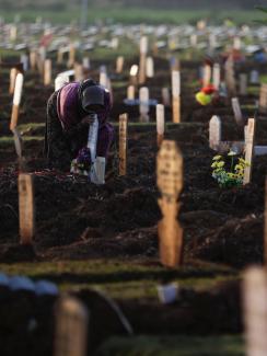 A woman mourns at the grave of her husband who passed away due to COVID-19, at a burial area provided by the government for COVID-19 victims as the country reports a record daily number of COVID-19 deaths, in Bekasi, Indonesia, on July 27, 2021