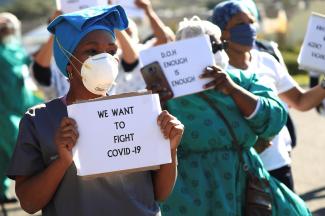Health care workers holding signs, protest over the lack of personal protective equipment (PPE) during the coronavirus disease (COVID19) outbreak, outside a hospital in Cape Town, South Africa, June 19, 2020. 