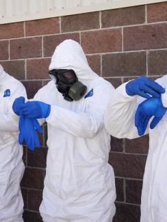 Soldiers from the U.S. Army put on one of three pairs of  gloves during the final session of personal protective equipment training at Ft. Carson in Colorado Springs, Colorado, on October 23, 2014.