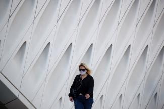 A woman wearing a face mask walks by The Broad Museum in downtown during the outbreak of the coronavirus disease (COVID-19), in Los Angeles, California, U.S., August 13, 2020