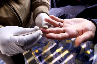 A nurse takes blood from a man who got a free HIV test on a bus on December 16, 2015. 