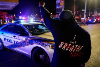 A man stands in front of a police car during the protest against the deaths of Breonna Taylor by Louisville police and George Floyd by Minneapolis police, in Louisville, Kentucky, on June 1, 2020.