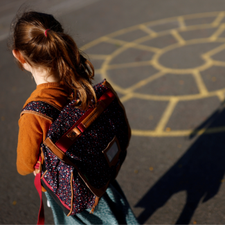 A child arrives at a primary school on the first day of the new school year after summer break in Vertou, France, on September 2, 2021