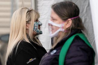 Interpreters wait at the entrance of a mobile coronavirus disease (COVID-19) vaccination clinic for members of the deaf and blind community, organized by the Swedish Medical Center in Seattle, Washington, U.S., March 19, 2021