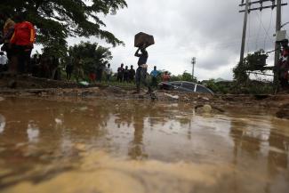 A man carries a piece of wood after the flooding which destroyed several homes at Trademore estate Abuja, Nigeria September 13, 2021. 