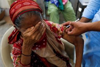 A woman, Basanti, 71, reacts as she receives a dose of the COVID-19 vaccine at a vaccination center in Karachi, Pakistan, on June 9, 2021.