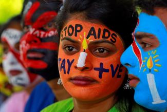 Students wear bright orange and blue face paint at an HIV/AIDS awareness event to mark the International AIDS Candlelight Memorial, in Chandigarh, India, on May 20, 2018. 