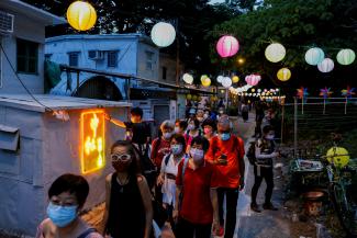 People walk near Chinese lanterns ahead of Mid-Autumn Festival at Tai O, in Hong Kong, China September 14, 2021.