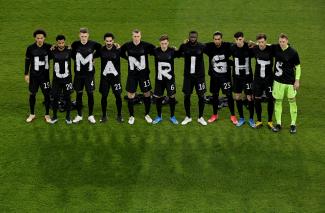 German soccer players pose before a World Cup match, bringing attention to labor rights abuses in Qatar, at MSV-Arena in Duisburg, Germany, on March 25, 2021. 