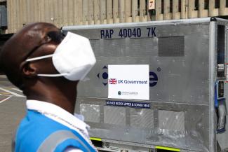 A health official stands next to a container holding a shipment of more than 400,000 doses of the Oxford-AstraZeneca COVID-19 vaccine, donated by the the British government, in Nairobi, Kenya.