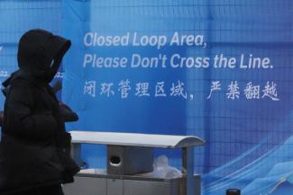 A  pedestrian passes a sign marking the barrier of the "Closed Loop," a precaution against the coronavirus disease (COVID-19) ahead of the Beijing 2022 Winter Olympics in Beijing, China, January 30, 2022.