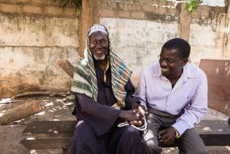 Foday shakes hands with Opthalmic nurse Gibil following surgery for advanced trachoma (trichiasis) in The Gambia in 2018.