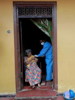 An elderly woman receives a dose of Sinopharm vaccine at her home from the Sri Lanka Army mobile vaccination unit against COVID-19, in Colombo, Sri Lanka, on September 14, 2021