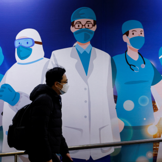 A man walks past mural art supporting medical professionals during the COVID-19 outbreak in Hong Kong on February 24, 2022.  REUTERS/Tyrone Siu