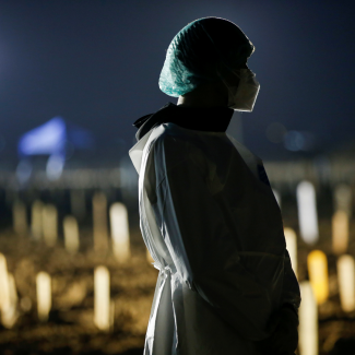 Toni Tanama awaits the funeral of his 51-year-old mother at a Muslim burial area provided by the government for COVID victims, in Jakarta, Indonesia, on July 7, 2021. 