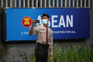 A police officer takes a picture outside the Association of Southeast Asian Nations (ASEAN) secretariat building, ahead of the ASEAN leaders' meeting in Jakarta, Indonesia, April 23, 2021.